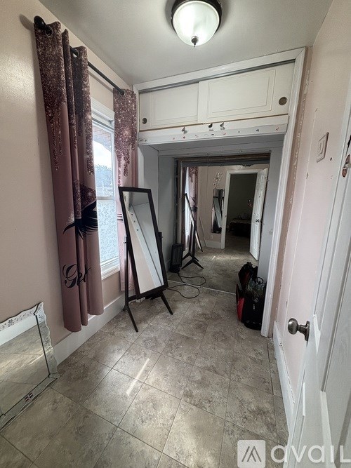 A room with a white door and a whiteboard leaning against the wall.