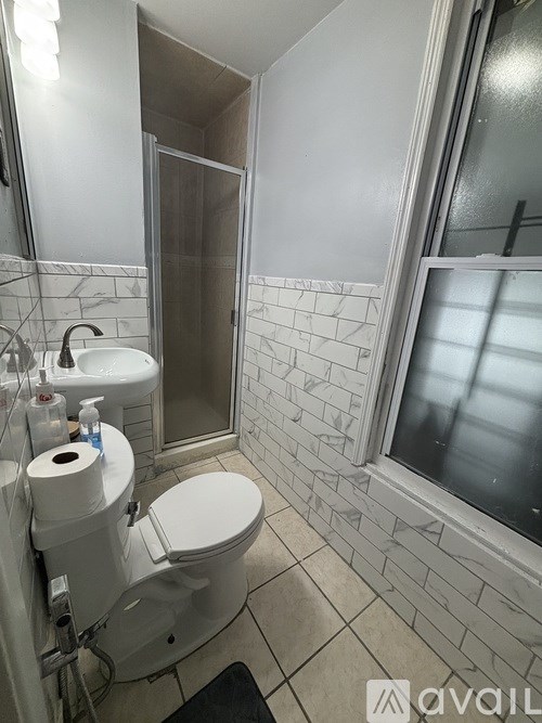 A bathroom with a toilet, sink, and shower.