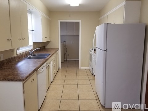 A kitchen with white appliances and cabinets.