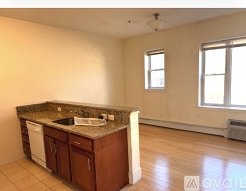 A kitchen with a granite countertop and a white dishwasher.