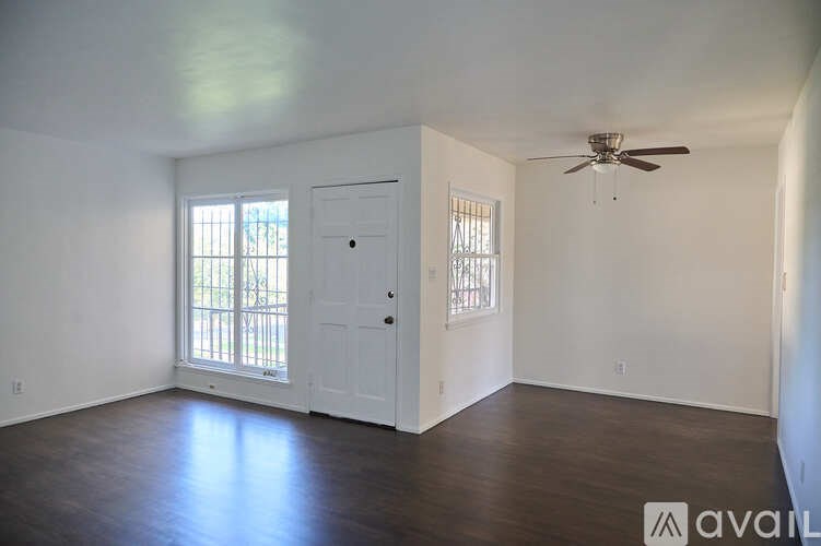 A room with a ceiling fan and a door leading to a balcony.