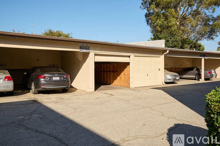 A parking lot with a building and cars parked in front.