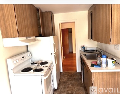 A kitchen with a white stove and wooden cabinets.