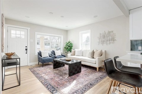 A living room with a black leather chair and a white couch.