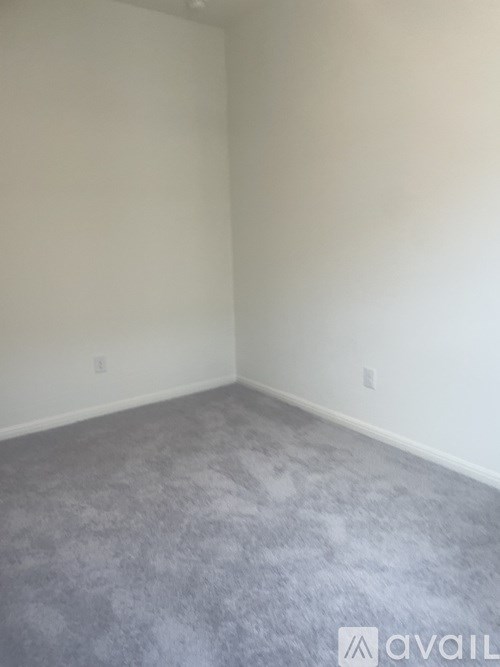 A room with a grey carpet and white walls.