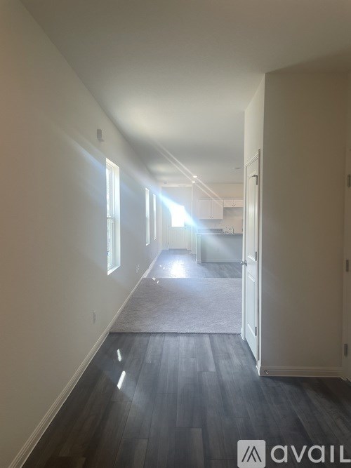 A long hallway with a carpeted floor and white walls.
