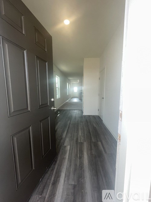 A long hallway with a row of doors on the left and a white wall on the right.