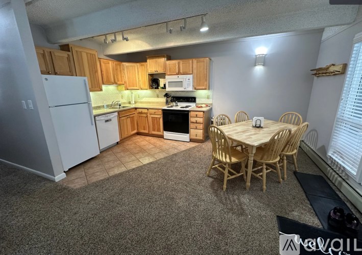 A kitchen with a dining table and chairs.