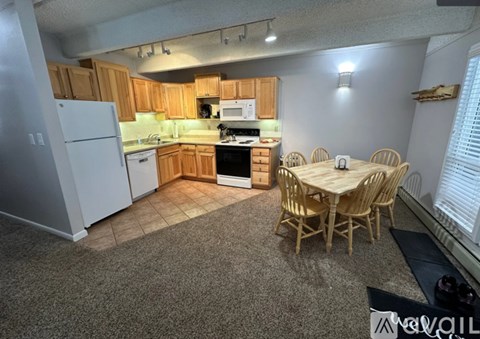 A kitchen with a dining table and chairs.