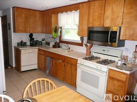 A kitchen with wooden cabinets and white appliances.