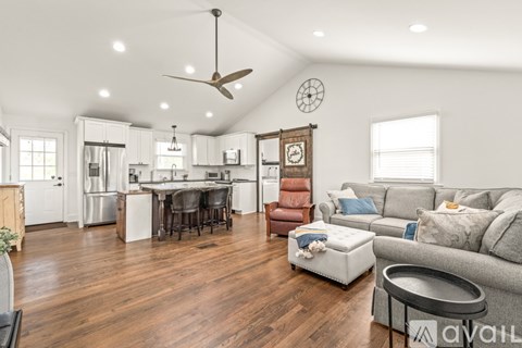 A living room with a grey couch and a wooden floor.