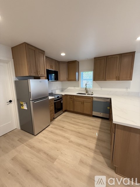 A kitchen with wooden cabinets and a refrigerator.