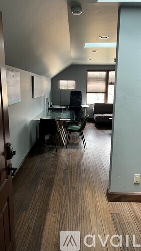 A room with a desk and chairs in it.