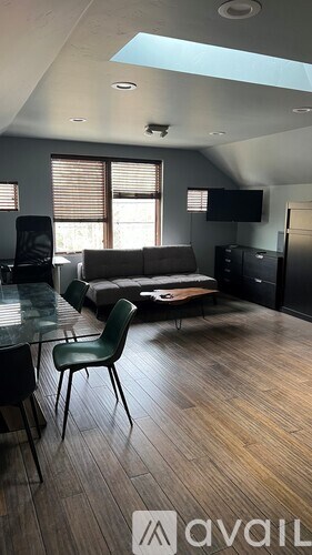 A living room with a couch, chair, and television.