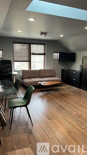 A living room with a couch, chair, and television.