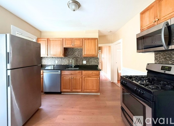 A kitchen with wooden cabinets and a black stove top oven.