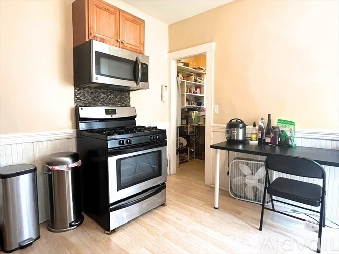 A kitchen with a black stove and a black chair.
