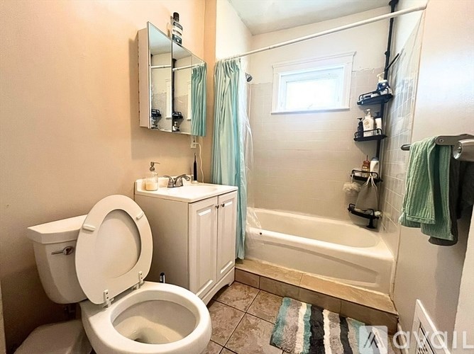 A white toilet with a sink and a bathtub in a bathroom.