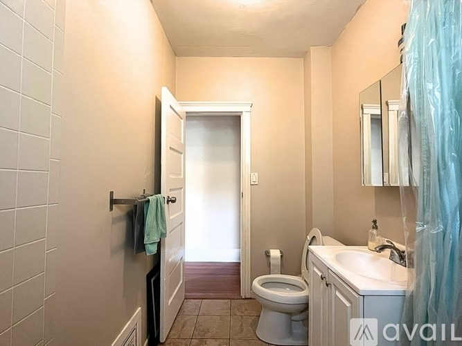 A bathroom with a toilet, sink, and mirror.
