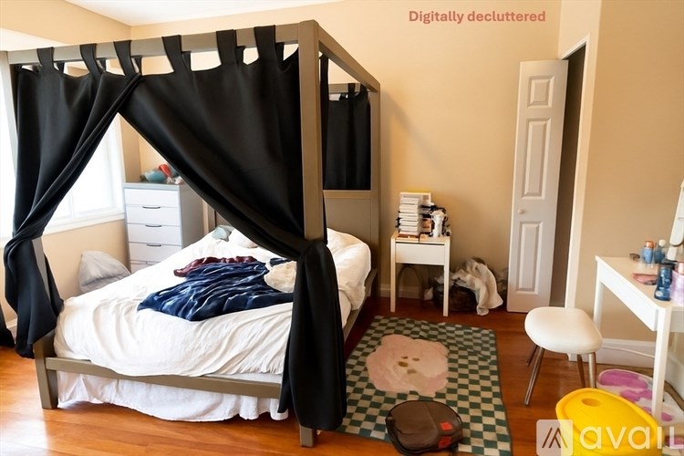 A bedroom with a canopy bed and a white bedspread.