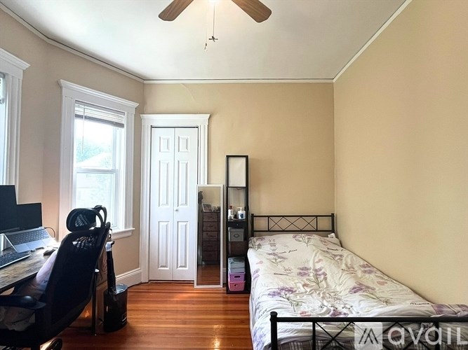 A bedroom with a bed, desk, and chair.