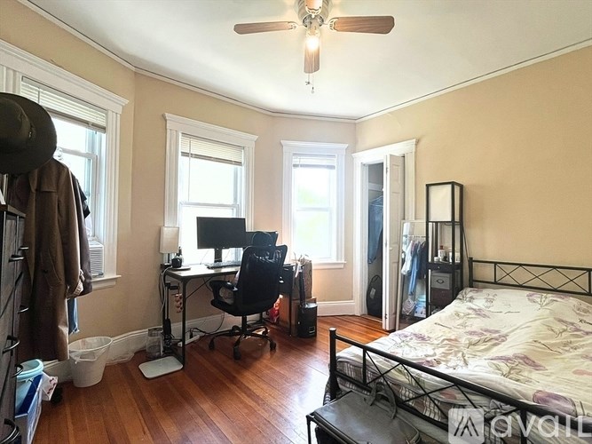 A bedroom with a bed, desk, and chair.