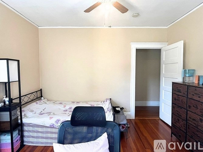 A bedroom with a bed, chair, and dresser.