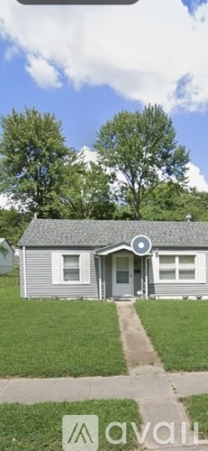 A house with a grey roof and a white door is for sale.