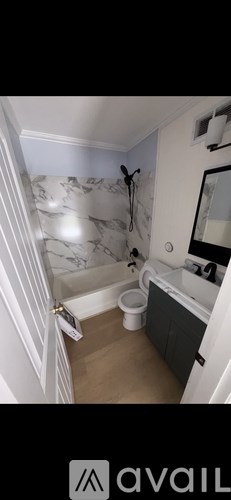A bathroom with a toilet, sink, and bathtub.