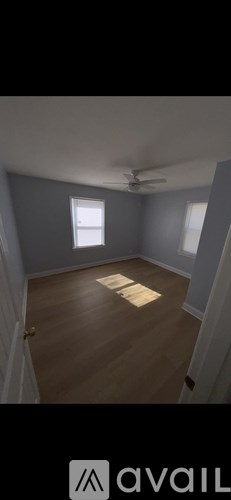 A room with wooden flooring and a window.