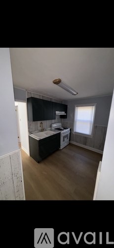 A kitchen area with a black cabinet and a white countertop.