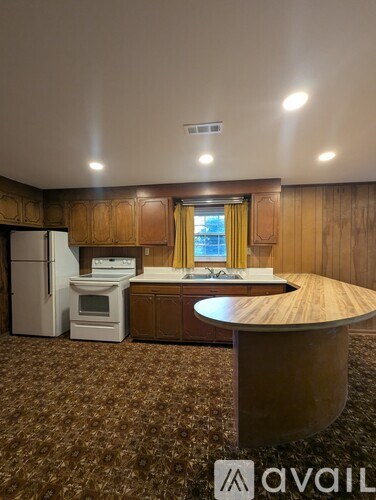 A kitchen area with a refrigerator, oven, and sink.