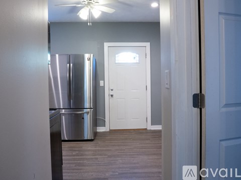 A kitchen with a refrigerator and a door.