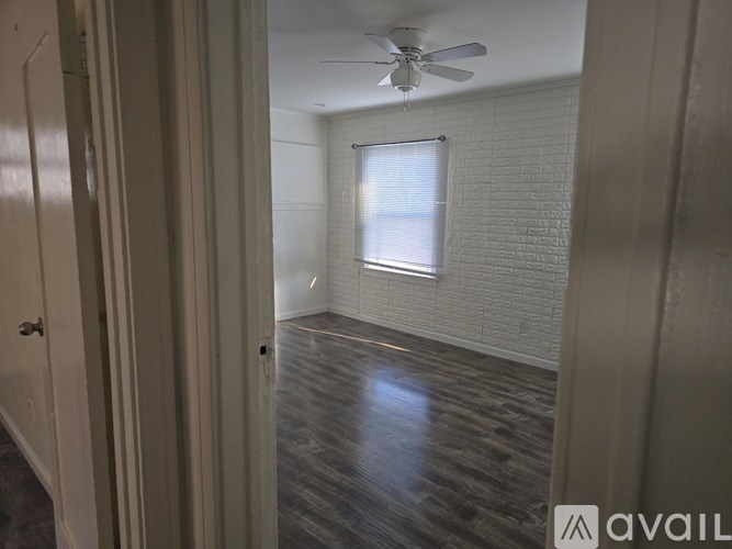 A room with a ceiling fan and a window with blinds.