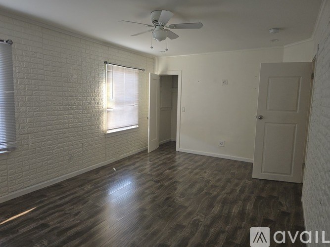 A room with a ceiling fan and wooden flooring.