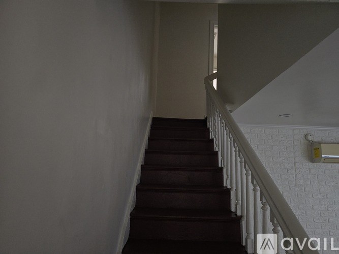 A staircase with a white railing and brown steps.