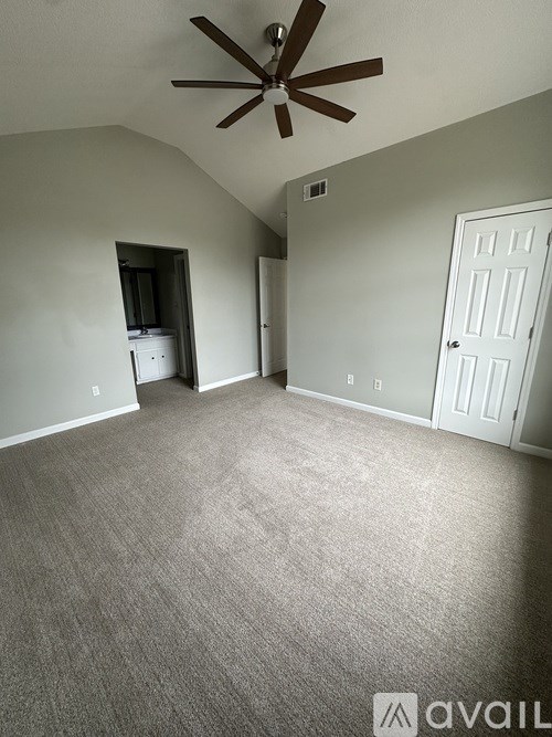 A room with a ceiling fan and carpeted floor.