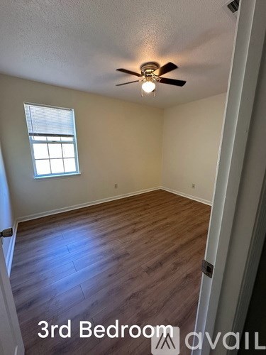 A room with a brick fireplace and wooden floors.