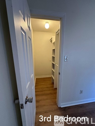 A kitchen with white cabinets and a marble countertop.