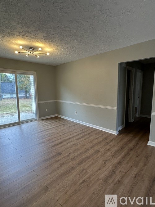 A room with wooden flooring and a ceiling light fixture.