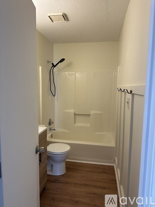 A white toilet is in a small bathroom with a walk-in shower.