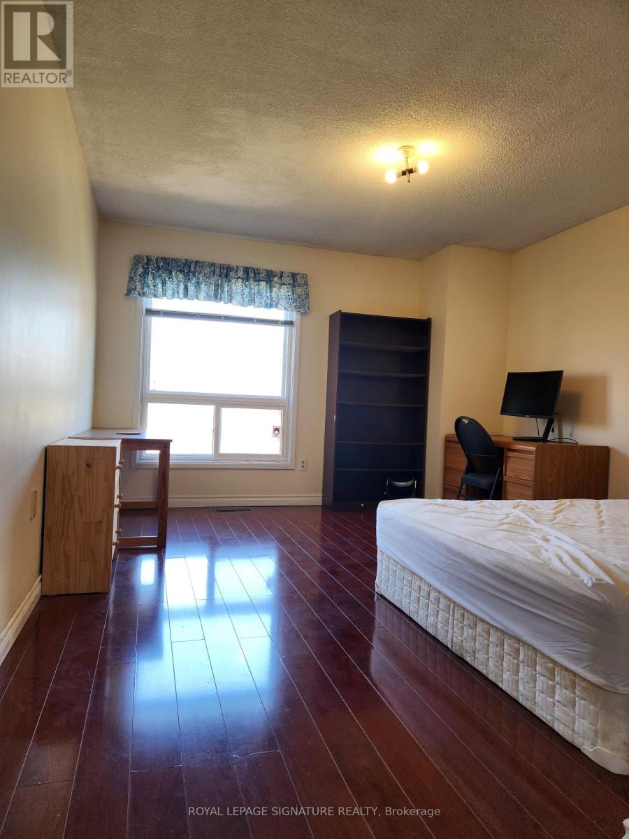 A bedroom with a bed, desk, and chair.