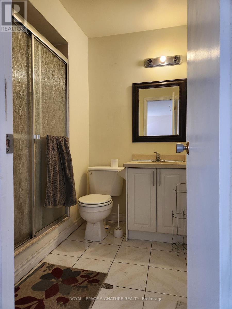 A white toilet sits in a bathroom next to a sink and a mirror.