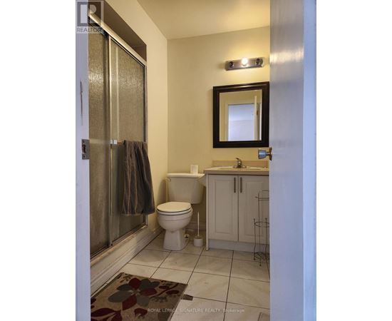 A white toilet sits in a bathroom next to a sink and a mirror.