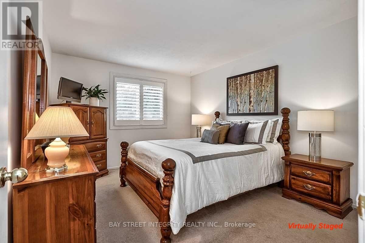 A bedroom with a bed, nightstand, and lamp.