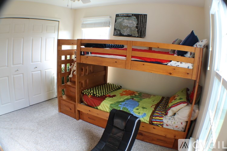 A wooden bunk bed with a slide in a room with white walls.