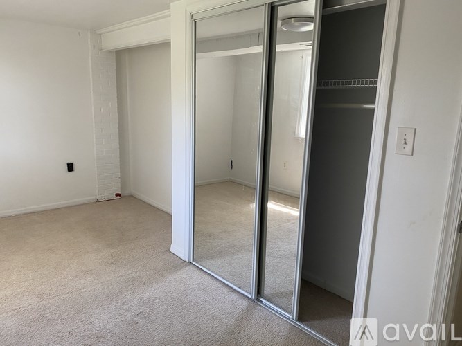 A room with a white door and a carpeted floor.