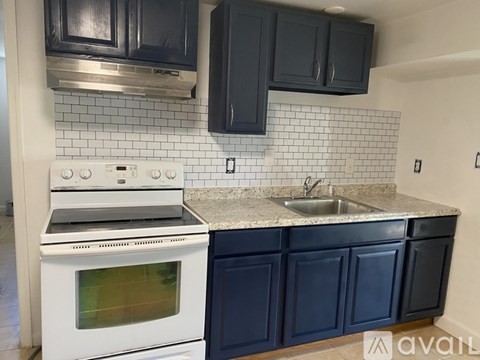 A kitchen with a white oven and black cabinets.