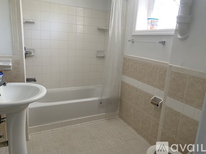 A bathroom with a white sink and a bathtub.