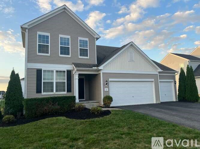 A two-story house with a garage is available for sale.